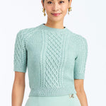 Woman wearing a soft mint cable knit sweater with a smooth, lightweight knit and polished neckline