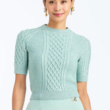 Woman wearing a soft mint cable knit sweater with a smooth, lightweight knit and polished neckline