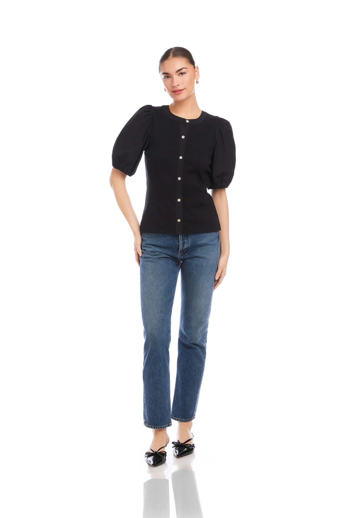 Woman wearing a black top and blue jeans on a white background