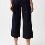 Person wearing navy blue pants on a white background