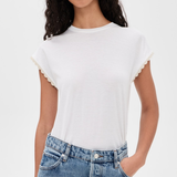 A woman wearing a white short-sleeve crewneck t-shirt with delicate scalloped edges on the sleeves, paired with light-wash blue jeans, against a plain white background.