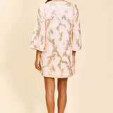 Woman wearing a light pink lace dress on a beige background