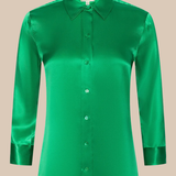 Green satin shirt on a beige background