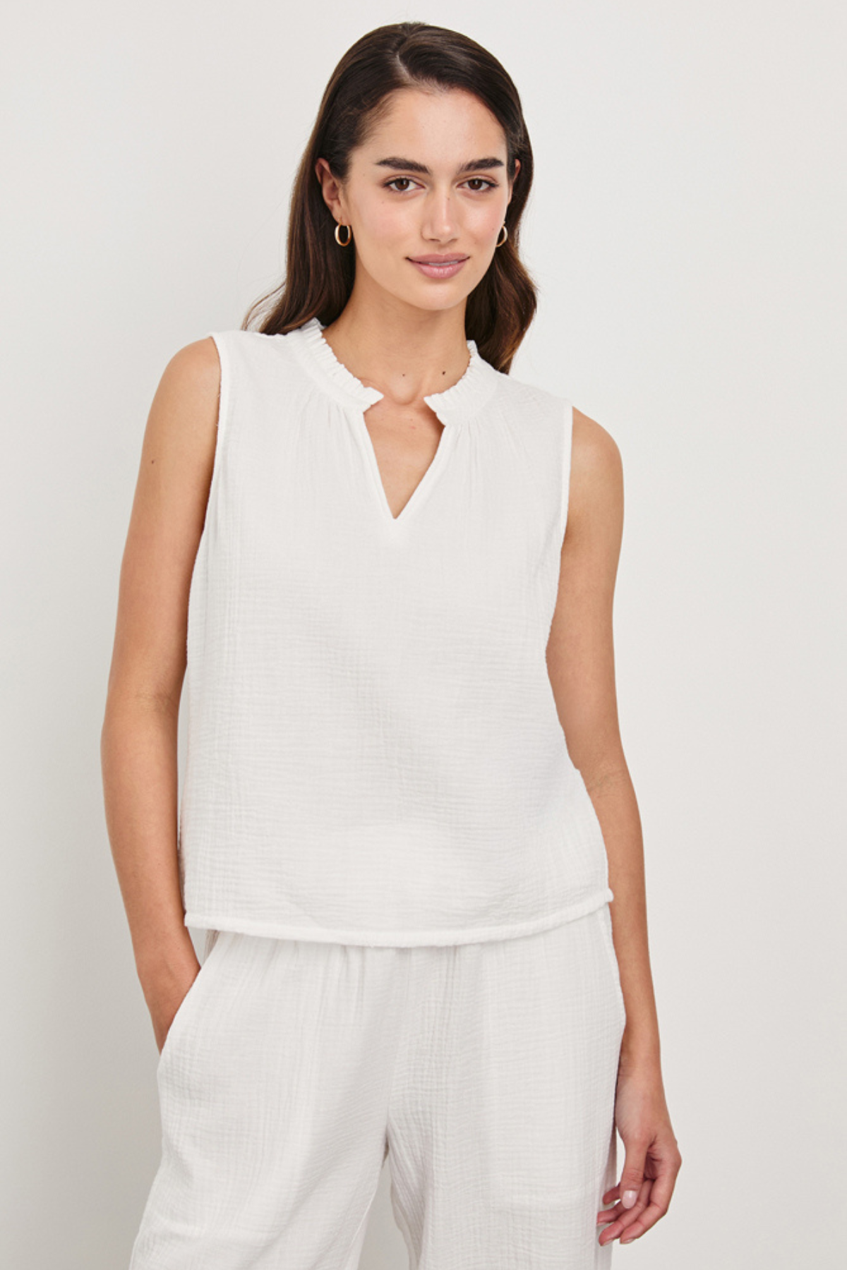 woman in white sleeveless top on white background 