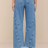 Wide-leg jeans worn by a person on a beige background