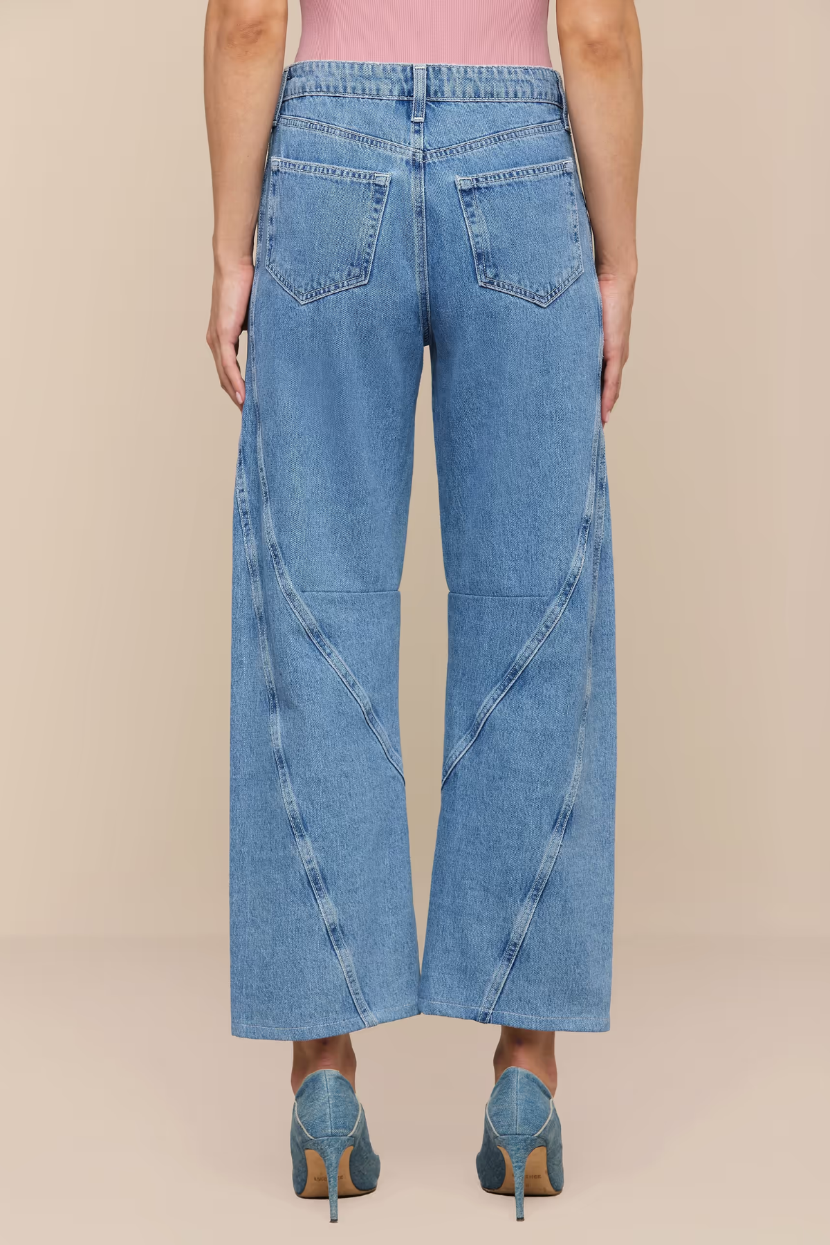 Wide-leg jeans worn by a person on a beige background