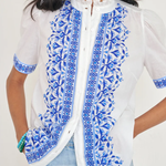 White top with blue printed detailing modeled on white background