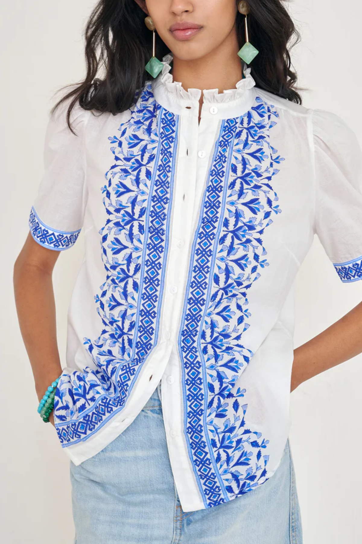 White top with blue printed detailing modeled on white background