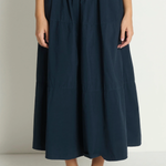 Person wearing a navy blue skirt on a plain background