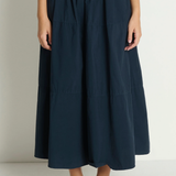 Person wearing a navy blue skirt on a plain background