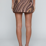 Model wearing a patterned low-rise mini skirt with a tailored silhouette and neutral tones.