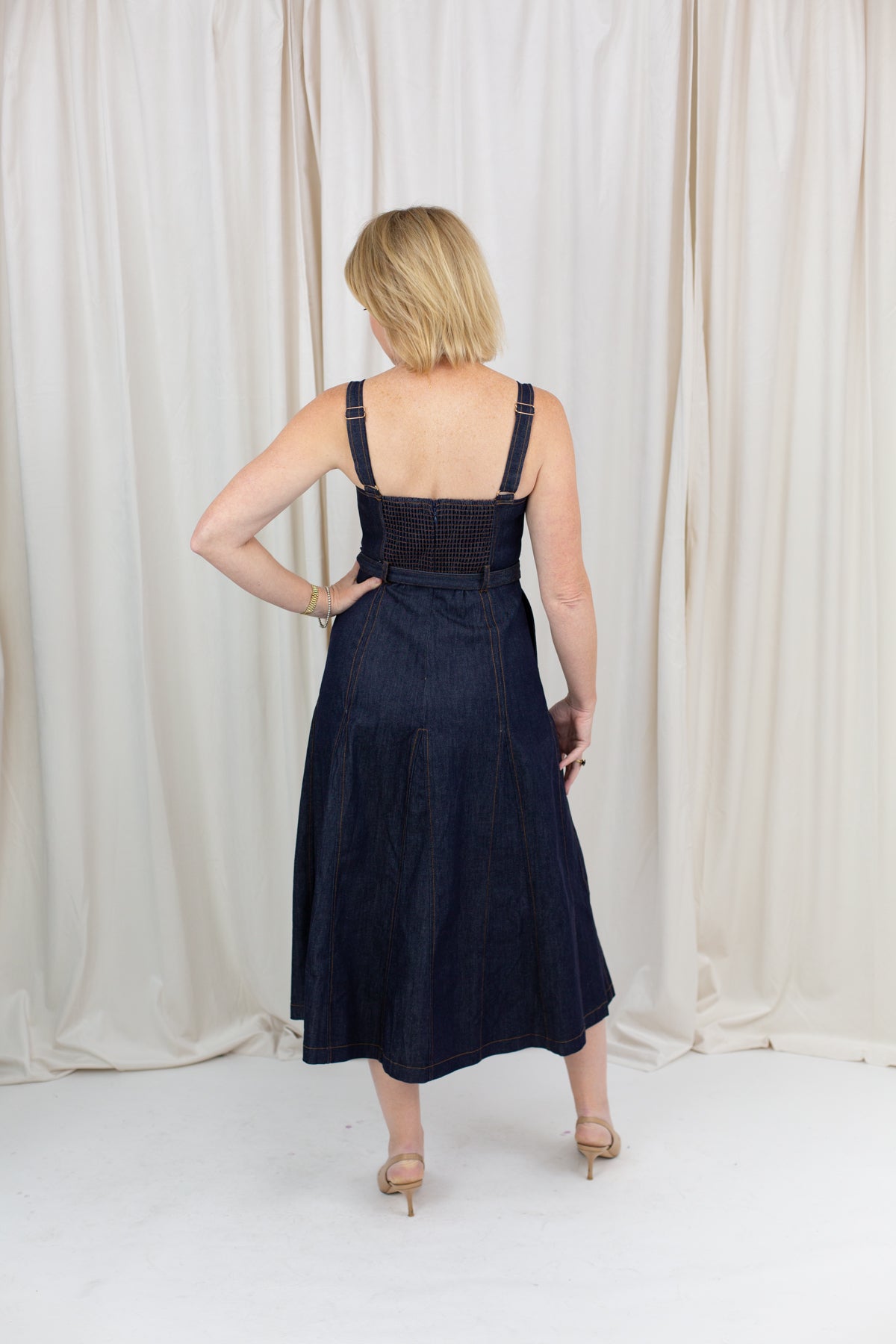 Indigo midi dress with a sweetheart neckline, corset-inspired seams, and a belted waist