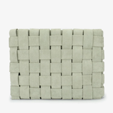 A woven rectangular clutch bag in a light sage green color, featuring a textured basketweave pattern, shown against a plain white background.
