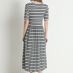 Woman wearing a black and white striped dress on a plain background