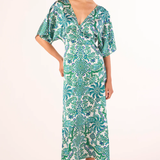 Woman wearing a green and white patterned dress on a white background