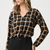Woman wearing black and gold patterned top against a white background
