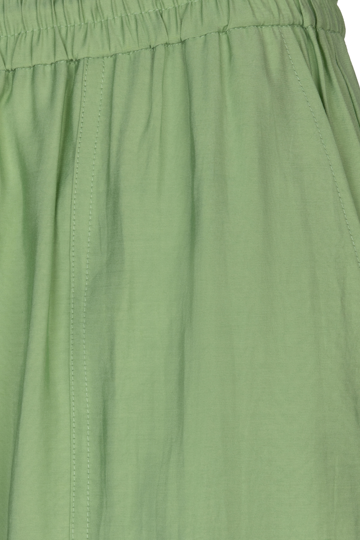 Close-up of a green skirt with a focus on texture and color.