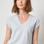 Woman wearing a light blue t-shirt against a plain background