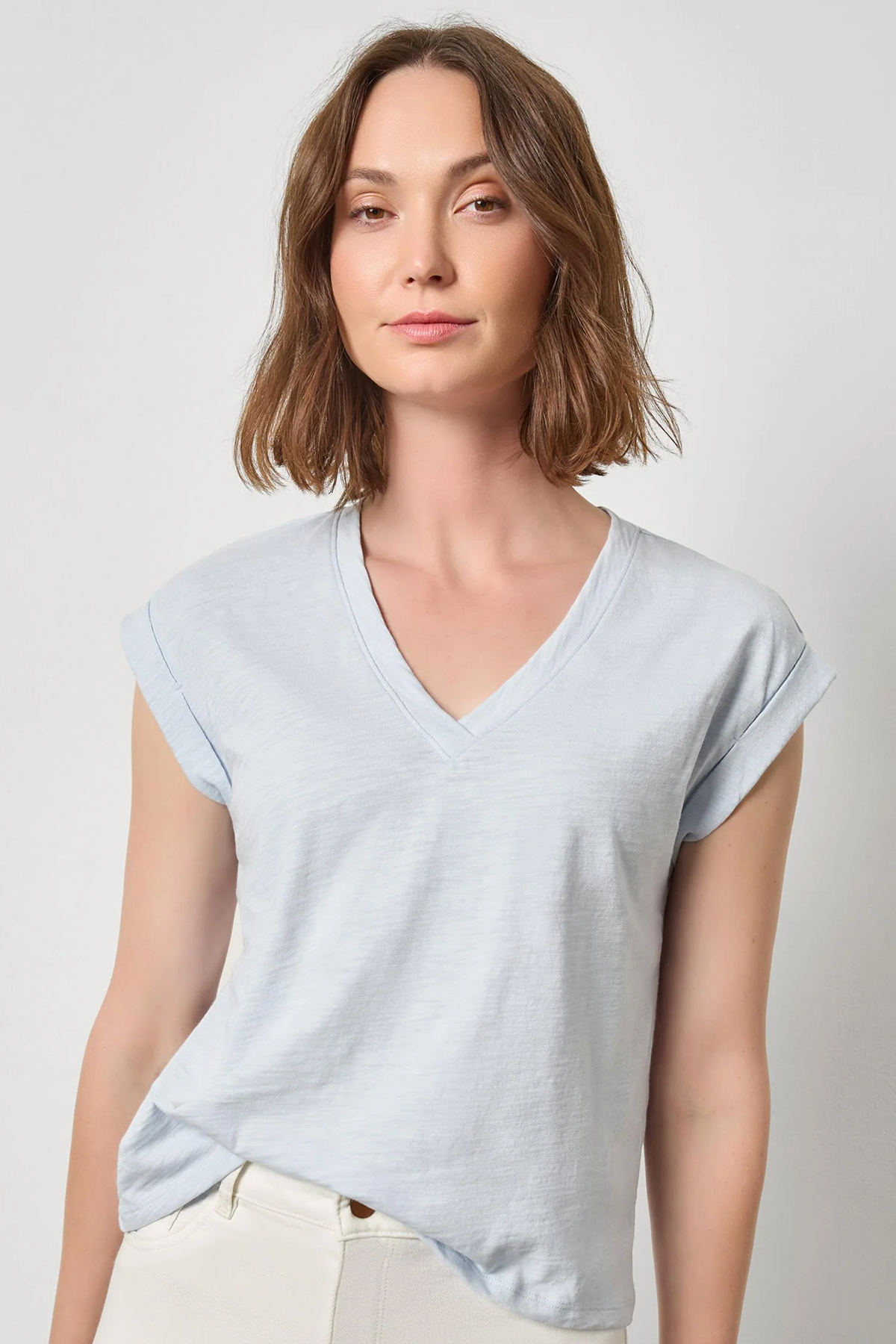 Woman wearing a light blue t-shirt against a plain background