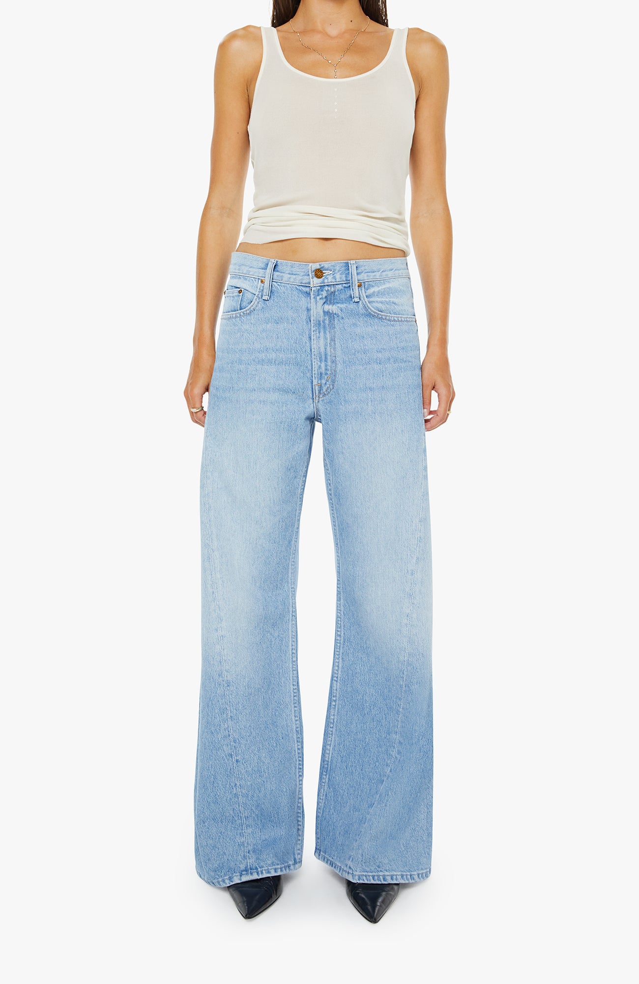 Person wearing light blue jeans and a white tank top on a white background