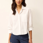 Woman wearing a white shirt and blue shorts on a plain background