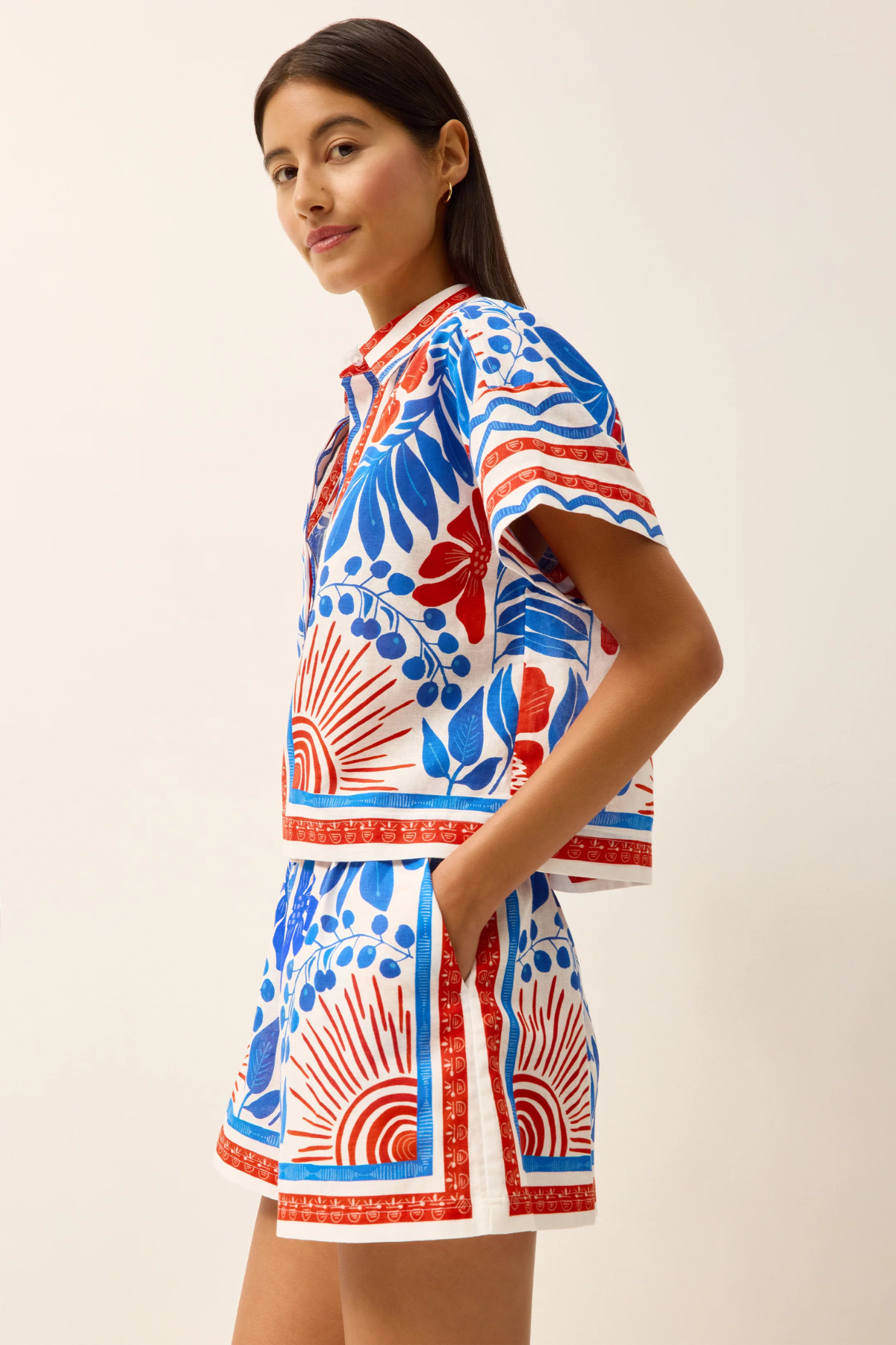 Woman wearing a colorful patterned dress on a plain background