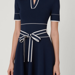 Navy blue dress with white trim on a plain background