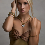 woman in two toned necklace on grey background 