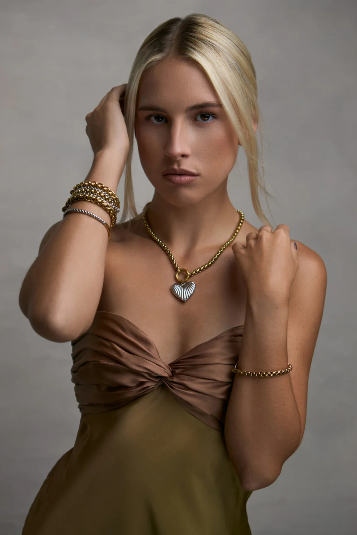 woman in two toned necklace on grey background 