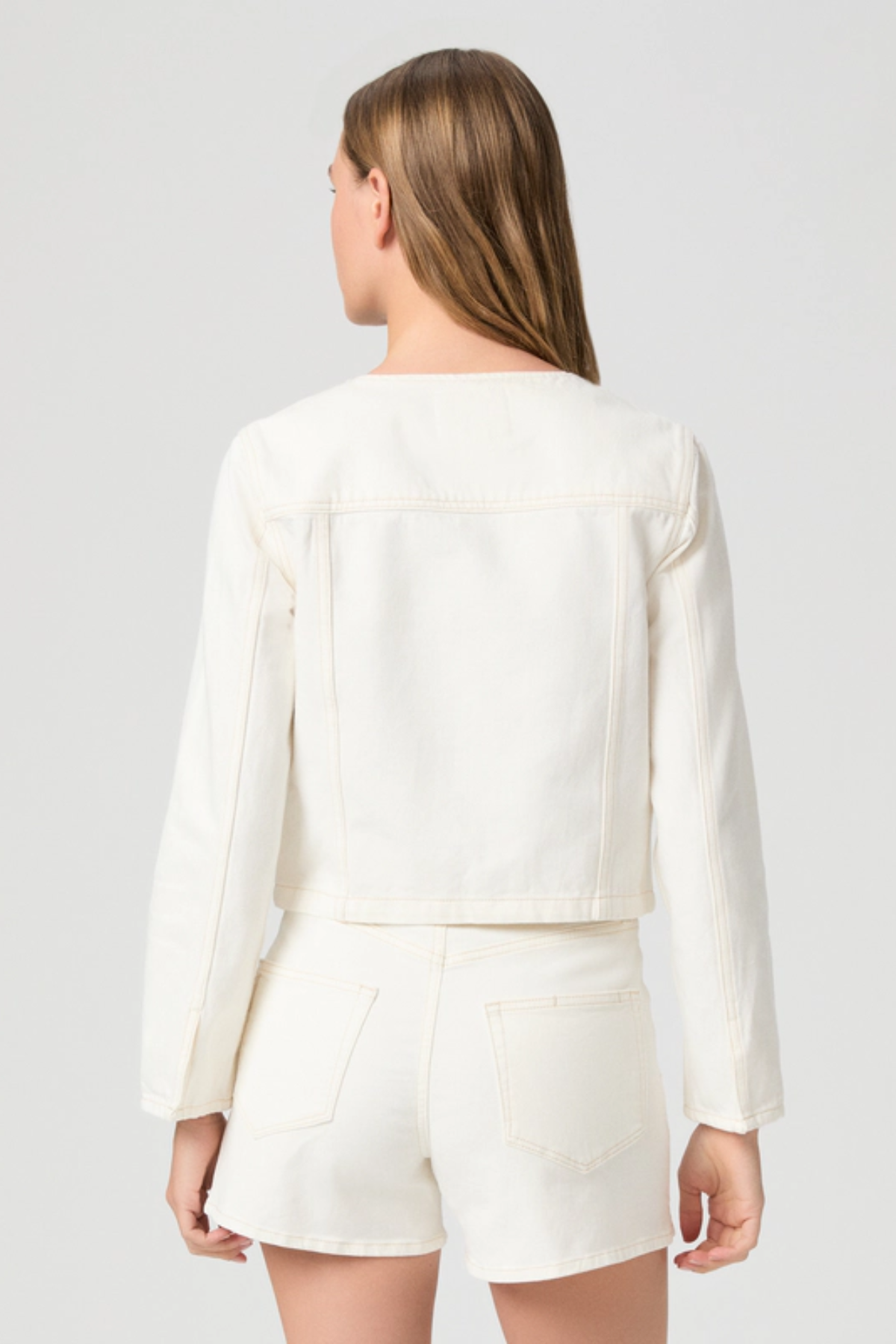 Person wearing a white outfit with a plain background