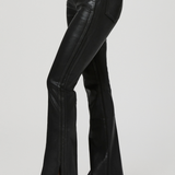 Black leather flared pants worn by a person on a light gray background