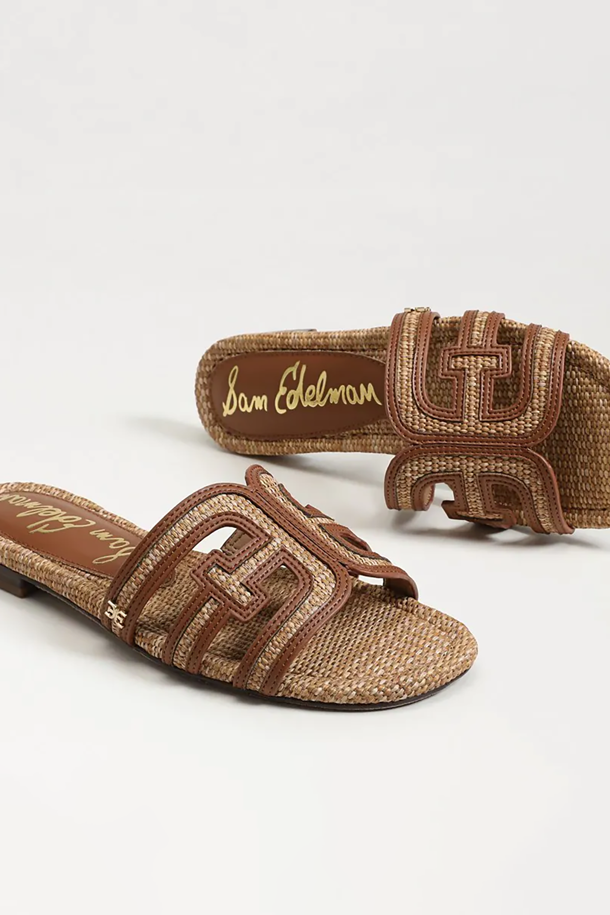 Brown sandals with woven design and visible brand name on a white background