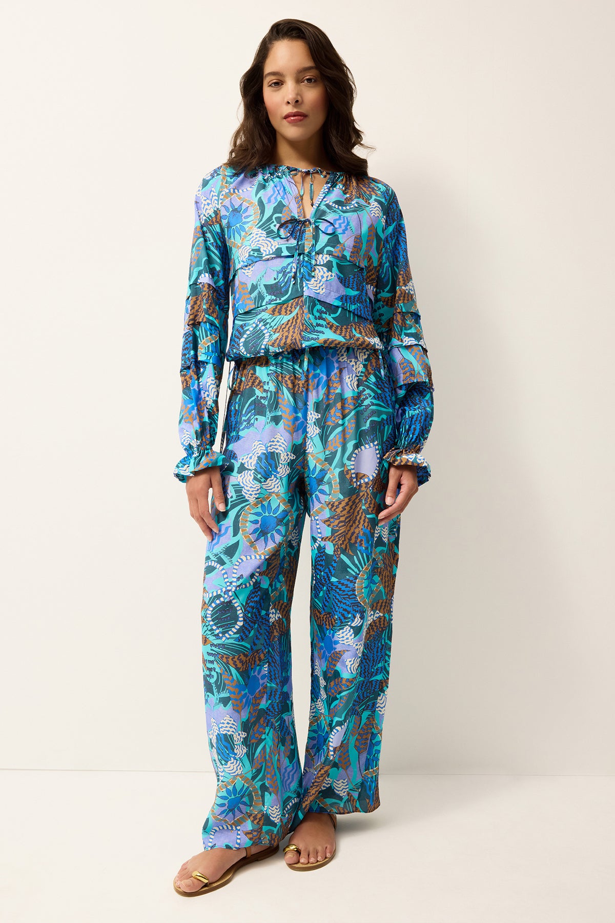 Woman wearing a blue floral patterned outfit on a white background