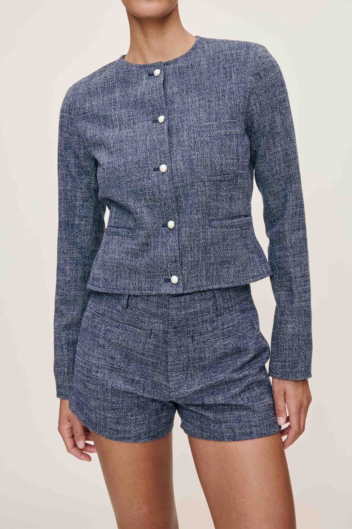 Blue textured set with jacket and shorts on a neutral background