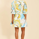 Woman wearing a colorful patterned outfit on a beige background