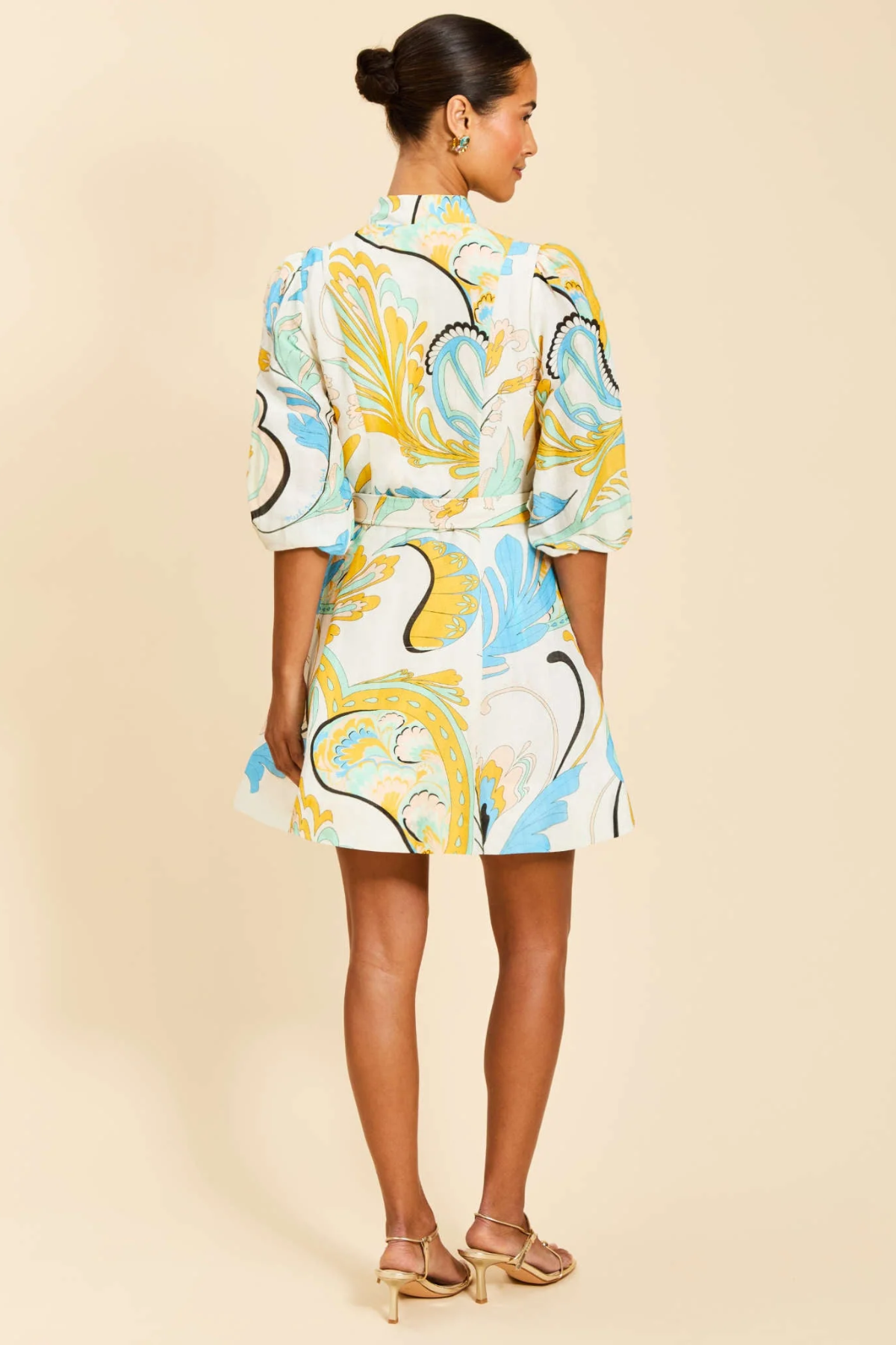 Woman wearing a colorful patterned outfit on a beige background