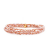 Pink beaded bracelet with a gold clasp on a white background