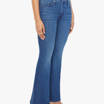 Woman wearing mid-wash flared jeans with a slim fit through the hip and gentle flare at the hem.