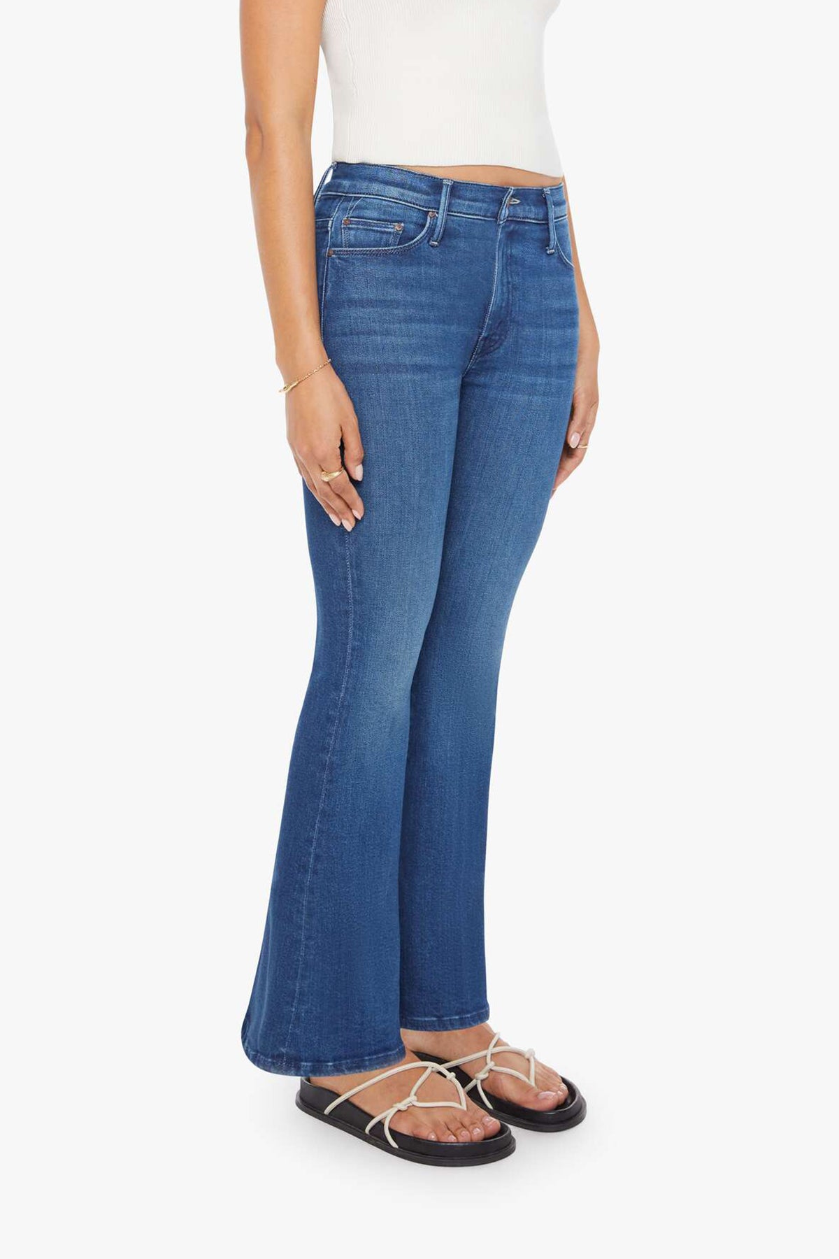 Woman wearing mid-wash flared jeans with a slim fit through the hip and gentle flare at the hem.