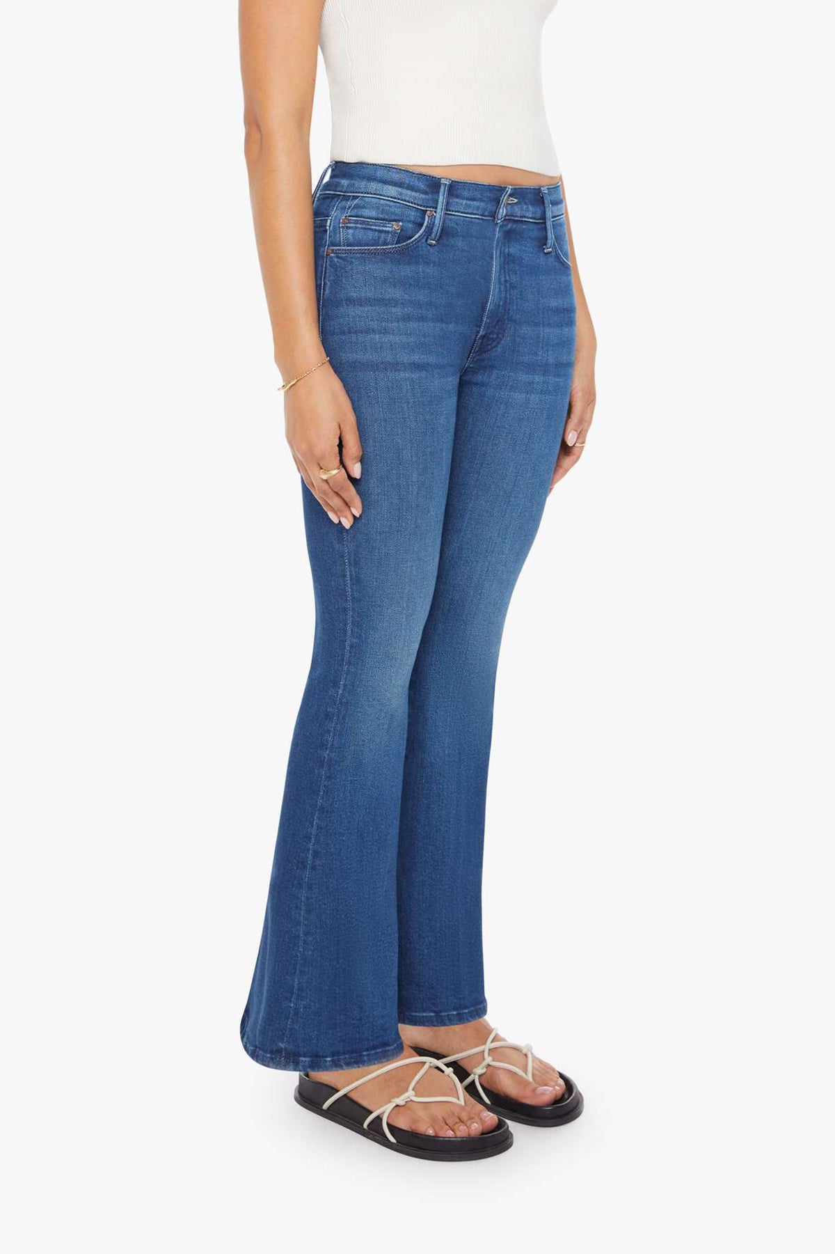 Woman wearing mid-wash flared jeans with a slim fit through the hip and gentle flare at the hem.