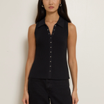 Woman wearing a black sleeveless button-up shirt against a plain background