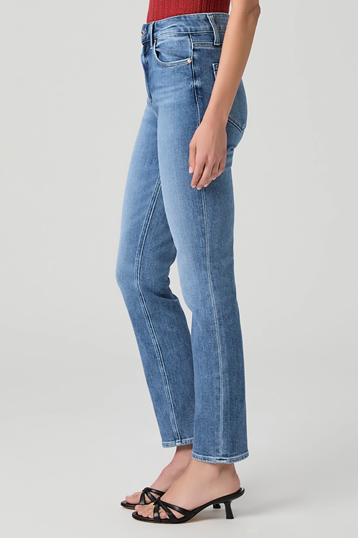 Woman wearing mid-wash straight-leg jeans with a streamlined, classic silhouette.
