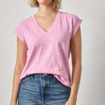 Woman wearing a pink t-shirt and blue jeans on a plain background