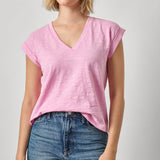 Woman wearing a pink t-shirt and blue jeans on a plain background
