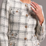 Close-up of a person wearing a patterned jacket with gold buttons.