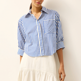 Woman wearing a blue and white striped shirt with a plain background