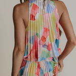 Multicolored floral dress worn by a person on a plain background
