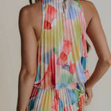Multicolored floral dress worn by a person on a plain background