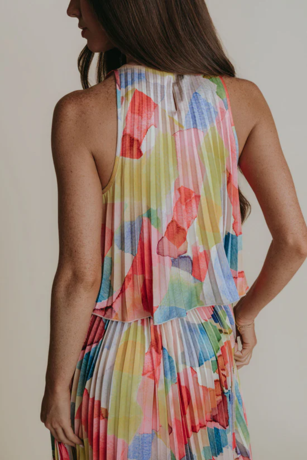 Multicolored floral dress worn by a person on a plain background