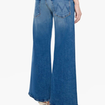 A model shown from the back wearing blue wide-leg flare jeans with a faded wash and silver high-heeled studded heels, against a plain white background.